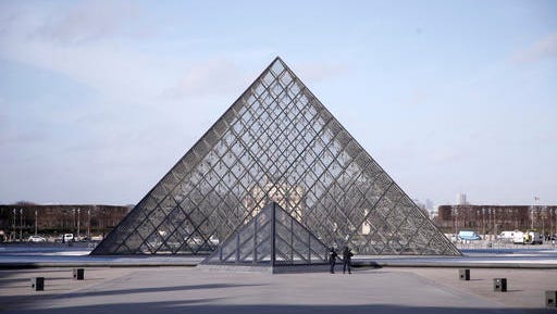 FILE - In this Feb. 3, 2017 file photo, police officers patrol at the pyramid outside the Louvre museum in Paris. Tourism to Paris is showing signs of revival after a yearlong slump attributed to deadly extremist attacks, violent labor protests, strikes and floods, according to figures released Tuesday Feb. 21, 2017.