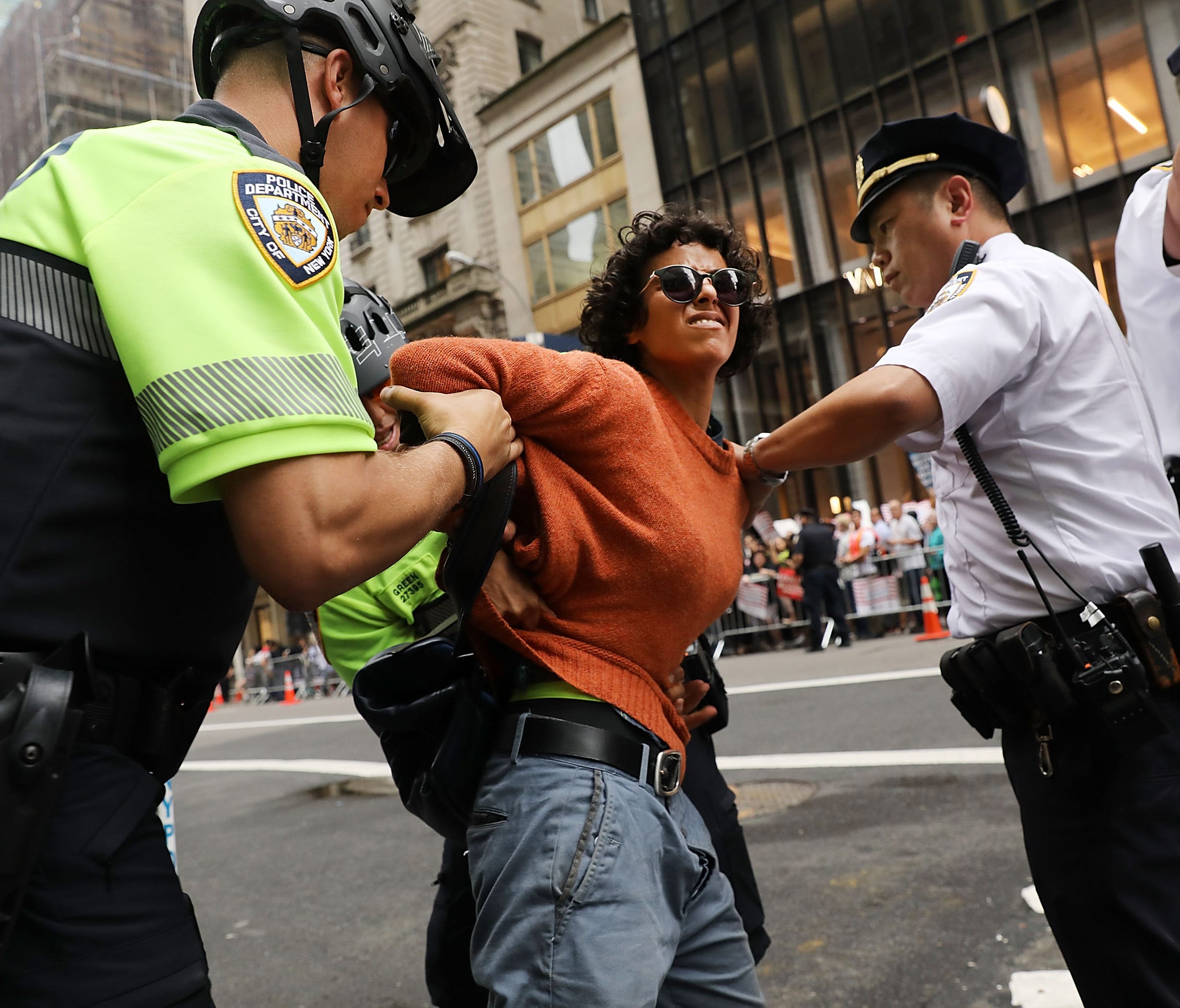 A woman is arrested during a pro-immigration rally outside of Trump Tower along Fifth Avenue on August 15, 2017, in New York City.