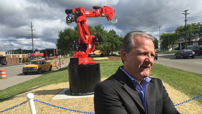 Chuck Dudek, Comau's North American CEO, talks about the reasons why the company donated the welding robot behind him to Southfield and had it installed on Telegraph Road near 8 Mile on Wednesday, Aug. 12, 2015.