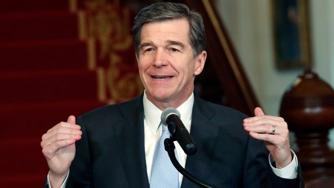 Gov. Roy Cooper holds a news conference Thursday at the Executive Mansion in Raleigh to announce that he signed compromise legislation that repeals major features of HB2.