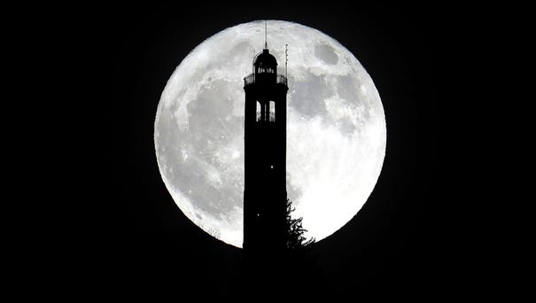 The super moon rises above the lighthouse of San...