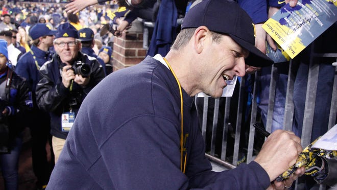 Jim Harbaugh signed autographs after Friday’s spring game, which featured a bigger, stronger, more fit team.