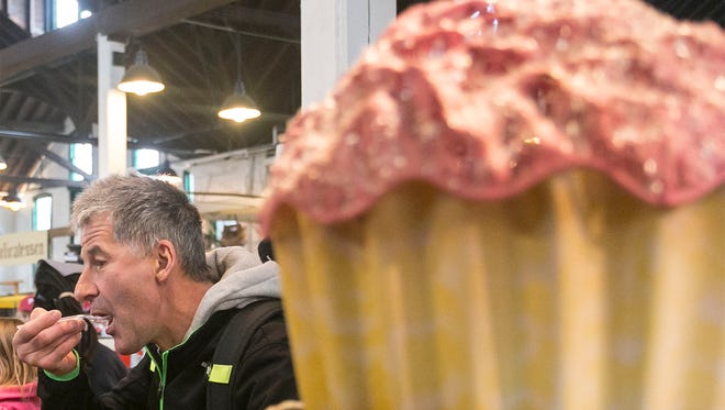 Hermann Holdernig, of Austria, tries his first cupcake at Just Cupcakes Tuesday, March 15, 2016, at the Central Market House. Today marked the first day of business in the Market House for owner Chris Martin (not pictured), who made the move to change her business plan. Amanda J. Cain photo