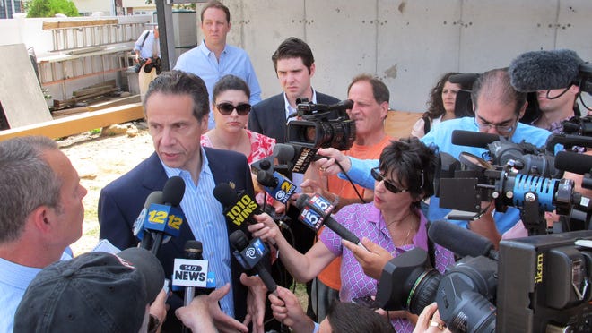
Gov. Andrew Cuomo, center left, is surrounded by the media Wednesday in Freeport, where he visited a homeowner still rebuilding from Superstorm Sandy. Cuomo was announcing a program to help Sandy victims but ended up fielding questions on the corruption commission.
