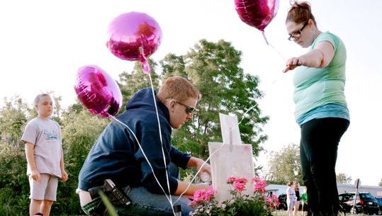 Christopher Gift and his fianceé, Carrie Kaziska, along with Gift's children, leave balloons and a candle by a memorial for 3-year-old homicide victim Isabel Rose Godfrey. (Randy Flaum photo)