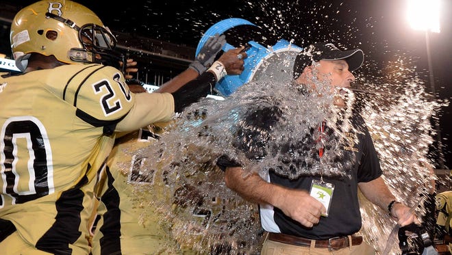 Bassfield head coach Lance Mancuso gets the traditional ice water bath as time expires in the 60-35 victory over Calhoun City in the MHSAA Class 2A football state championship on Friday, December 5, 2014, at Davis Wade Stadium on the Mississippi State University campus in Starkville.