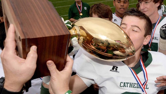 Cathedral defensive back Andrew Beesley kisses the trophy after the Green Wave beat St. Aloysius 49-14 to capture the MHSAA Class 1A state football championshp game on Friday, December 5, 2014, at Davis Wade Stadium on the Mississippi State University campus in Starkville.