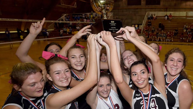 The Our Lady Academy Crescents celebrate with the Class I trophy after beating Resurrection on Saturday in the MHSAA volleyball championships at Millsaps College.