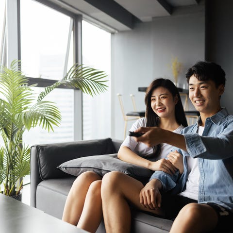 Two people watching TV on the couch.