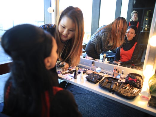 A United Airlines flight attendant has her makeup done