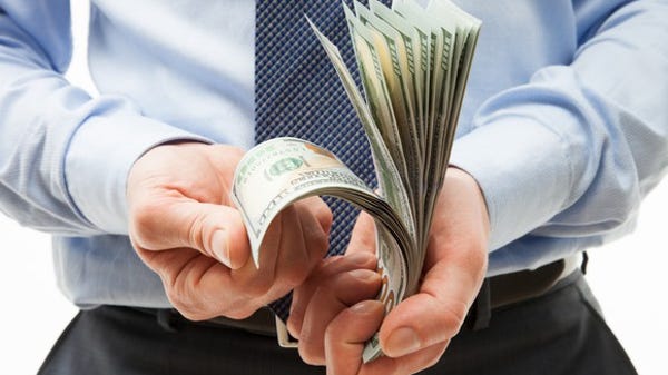A man in a suit counting cash.