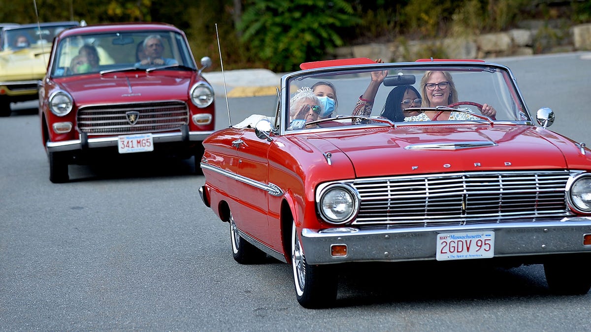 Liz Lowther of Milford leads a caravan of classic  cars as she  drives Rita Doucette of Hopkinton in her 1963 Ford Falcon during Doucett'e 100th birthday celebration Friday.