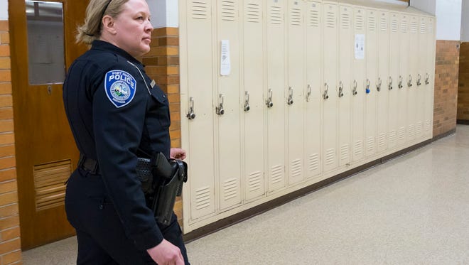 Port Huron Police school resource officer Laura Phillips walks through the hallways at Port Huron High School while students are in class March 8. 
