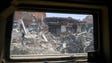 Damaged buildings are seen through the window of an