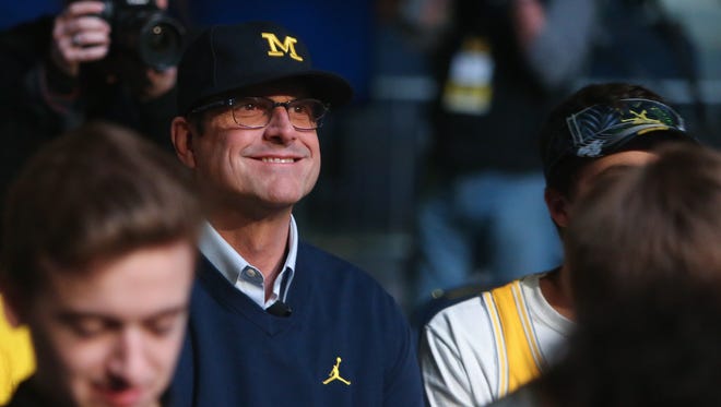 Michigan head coach Jim Harbaugh sits with students before the Signing of the Stars event at the Crisler Center in Ann Arbor on Wednesday, Feb. 1, 2017.
