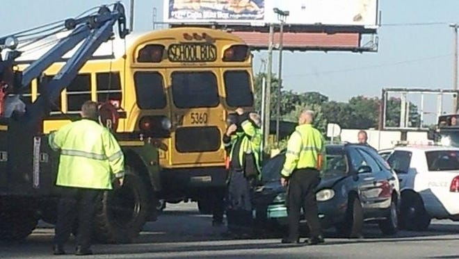 A Warren Township bus is lifted off a car after an accident at Post Road and Washington Street Friday.
