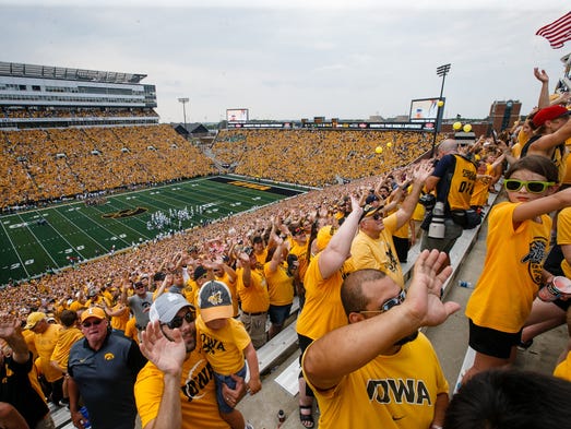 Fans wave to children at the University of Iowa Stead