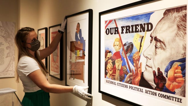 Kaylynn Washnock Stooksbury, outreach archivist for the Richard B. Russell Library for Political Research and Studies, installs a traveling exhibit of campaign posters at the Special Collections Building on the UGA campus.