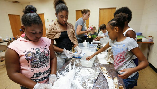 From left, Blessins Singleton, 9, Aryionna Jordan, 12, and Tyneisha Hawkins, 11, create artwork from paper mache at Grant Avenue Baptist Church in northwest Springfield on Thursday as part of a free camp put on by the Springfield-Greene County Park Board, the Springfield Regional Arts Council and Heart Academy of Music.