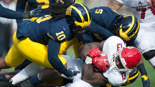 Michigan linebacker Aubrey Soloman (5) assists on a tackle of Rutgers running back Gus Edwards.