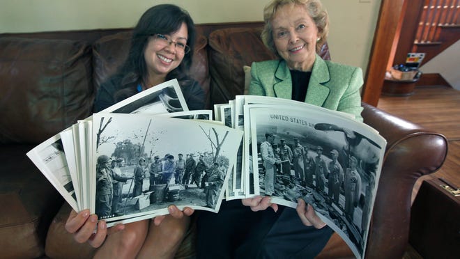 Tiana Stephens, 35, of Rochester, left, and Betty Perkins-Carpenter, 83, of Penfield show some of the photos of Korean War soldiers who will hopefully be identified through a online gallery project involving Perkins-Carpenter, the  Democrat and Chronicle  and Kodak Alaris. Stephens recognized her grandfather Crawford Flynn in one of the photos.