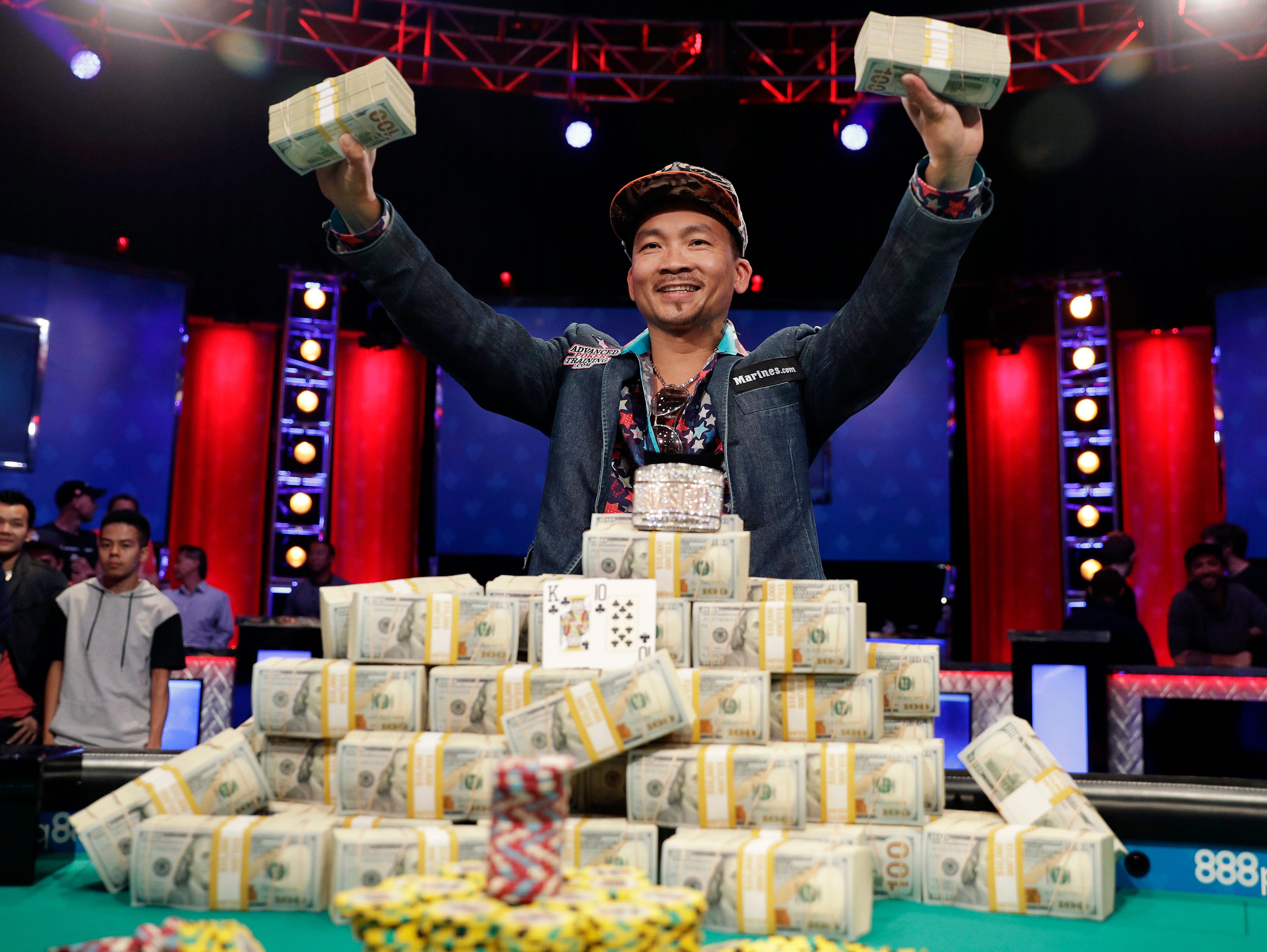 Qui Nguyen hoists his winnings after beating Gordon Vayo at the final table to win the World Series of Poker.
