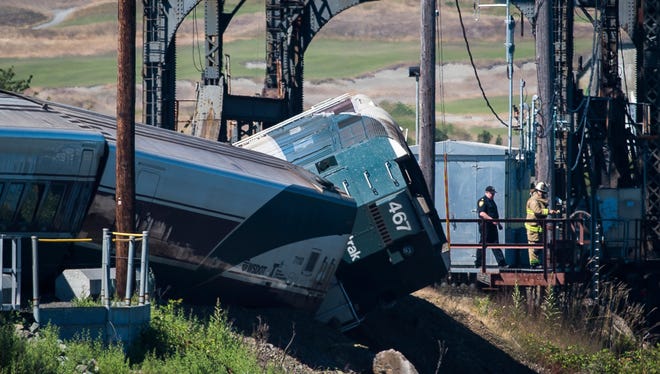 In this July 2, 2017 file photo, emergency crews respond to the scene of a train derailment near Chambers Bay in Tacoma, Wash.