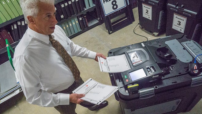 Richard LeBlanc feeds test ballots into the machine.