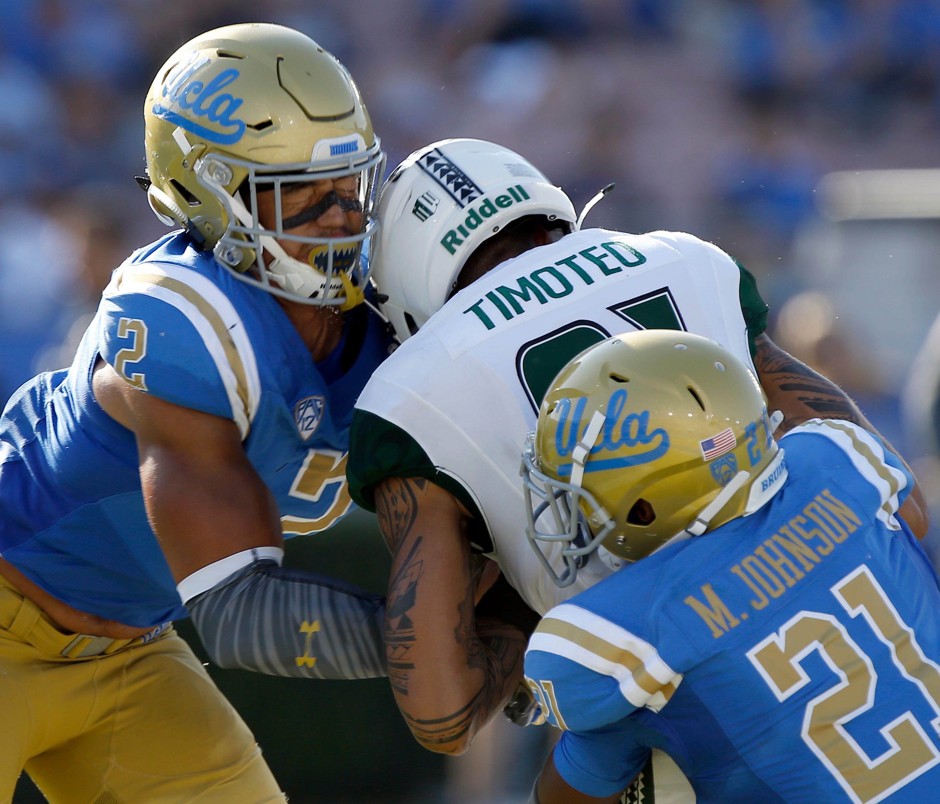 In this Sept. 9, 2017, file photo, Hawaii wide receiver Kalakaua Timoteo, center, drops the ball and gets leveled by UCLA linebacker Josh Woods, left, and hit from behind by defensive back Mossi Johnson (21). Woods was penalized for targeting and eje
