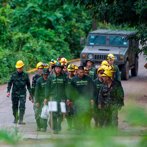 Thai soldiers walk out from the Tham Luang cave...