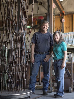 Sculptor Kevin Caron and his business manager, Mary Westheimer, stand beside his sculpture
"Banked Bramble" during its creation.