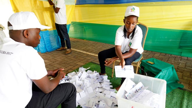 Poll workers count ballot papers after the close of poll station in the presidential and general elections at a polling station in Kigali, Rwanda, on August 4, 2017.