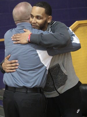 Josh Artis hugs Kenwood High boys basketball coach Dennis Pardue at Clarksville High prior to the start of a high school basketball game last January.