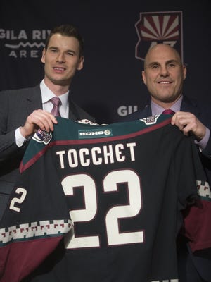 Coyotes GM John Chayka (L) and new head coach Rick Tocchet hold up a Tocchet jersey at his announcement press conference at Gila River Arena in Glendale, Ariz. on July 13, 2017.