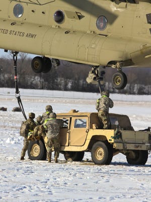 A ground crew assigned to Company A, 626th Brigade Support Battalion, 3rd Brigade Combat Team, 101st Airborne Division (Air Assault) connects sling legs to a CH-47 Chinook helicopter in preparation to rapidly transport an M998 high mobility multipurpose wheeled vehicle during a brigade-level air assault operation, Jan. 19, at Fort Campbell.  The operation provided the Screaming Eagle Soldiers an opportunity to showcase their unique capabilities as the world’s only air assault division.  (U.S. Army photo by Staff Sgt. Cody Harding, 3rd BCT, 101st Abn. Div. Public Affairs)