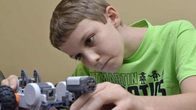Colby Elliott, 10, builds a robot at the robotics camp Monday afternoon at the University of Tennessee at Martin Extension Center.