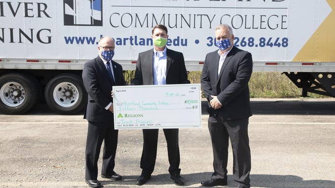 Heartland Community College President Keith Cornille, left, accepts a donation from Bart Rose, Market Executive for Regions Bank in Central Illinois, center along with Chris Downing, Executive Director, Heartland Foundation, right.