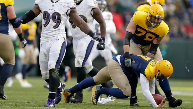 Baltimore Ravens outside linebacker Matt Judon (99) celebrates a safe as Green Bay Packers quarterback Brett Hundley (7) us helped up by Green Bay Packers offensive tackle Jason Spriggs (78) during the 4th quarter of the Green Bay Packers 23-0 loss to the Baltimore Ravens at Lambeau Field in Green Bay, Wis. on Sunday, November 19, 2017.