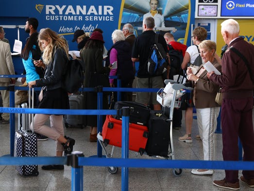 Fliers queue at a Ryanair customer service desk at