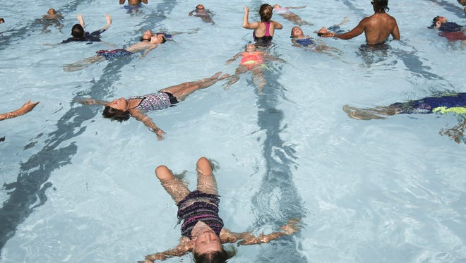 Participants of the World's Largest Swim Lesson practice back floating at Dunham Otto-Armleder Pool Thursday morning.