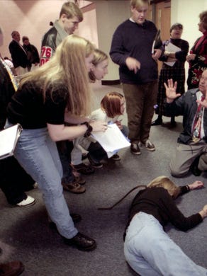 West High School students study a recreated crime scene with their teach Jenny Sharpe acting as a homicide victim in November 1995 while Knoxville Police crime scene specialist Arthur Bohanan gives students tips on collecting evidence.