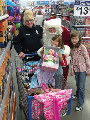 Santa and Fairview officer Carla Cottrell assist local children during the 2016 Shop WIth A Cop event.