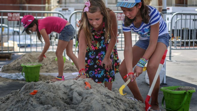 McKenzie Rhodes, 9, Emily Mendoza, 9, and Summer Emert, 9, play with the sand at the Sandsational Summer outdoor festival at the Spa Resort Casino in Palm Springs on Saturday, July 2, 2016.