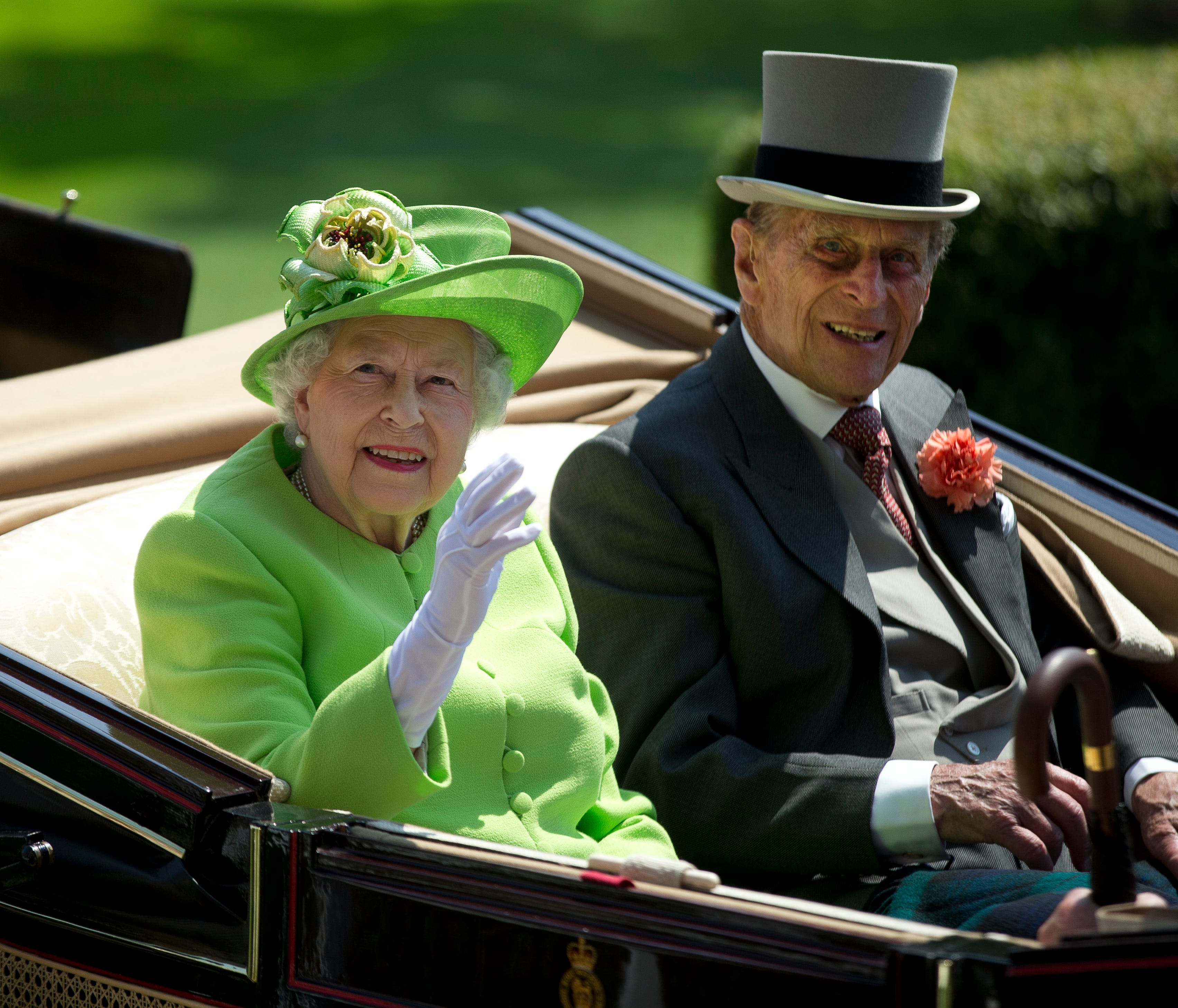 Britain's Queen Elizabeth II, left, waves to the crowd with Prince Philip at right, as they arrive by open carriage to the parade ring on the first day of the Royal Ascot horse race meeting in Ascot, England, Tuesday, June 20, 2017. (AP Photo/Alastai