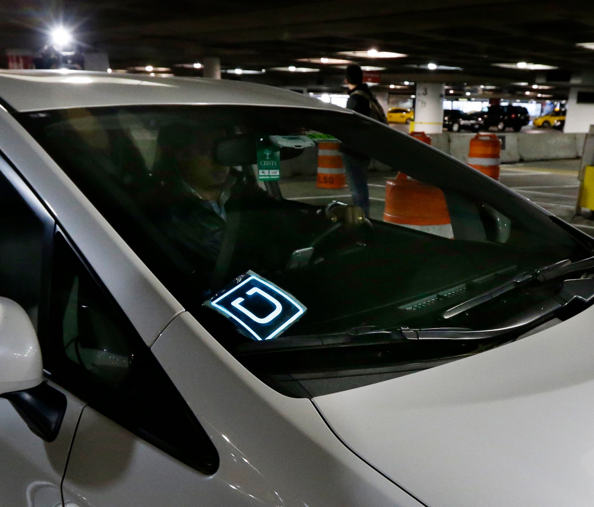 A  driver for Uber Technologies Inc., arrives at an authorized customer pick up area at Seattle-Tacoma International Airport, in Seattle. A federal judge in Seattle on Tuesday, April 4, 2017, temporarily blocked the city's first-in-the-nation law all