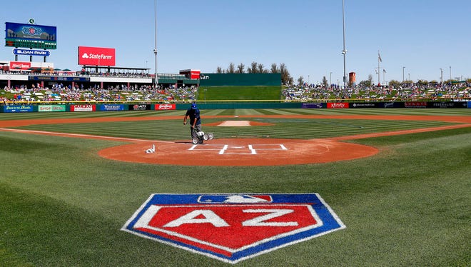 A groundskeeper paints the batters box prior to a spring training baseball game between the Los Angeles Angels and the Chicago Cubs March 9, 2018, in Mesa.