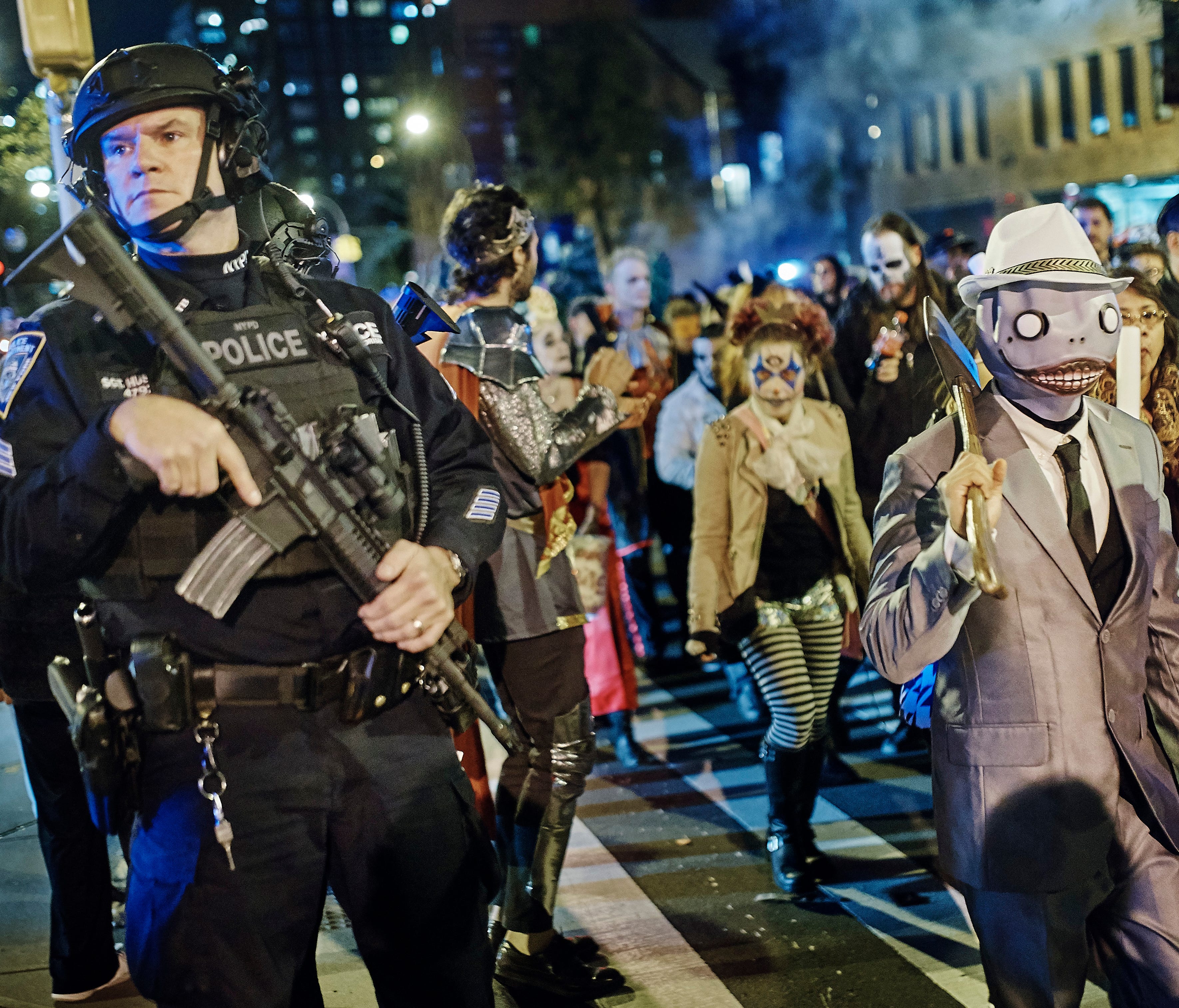 Heavily armed police guard as revelers march during the Greenwich Village Halloween Parade, Tuesday, Oct. 31, 2017, in New York.