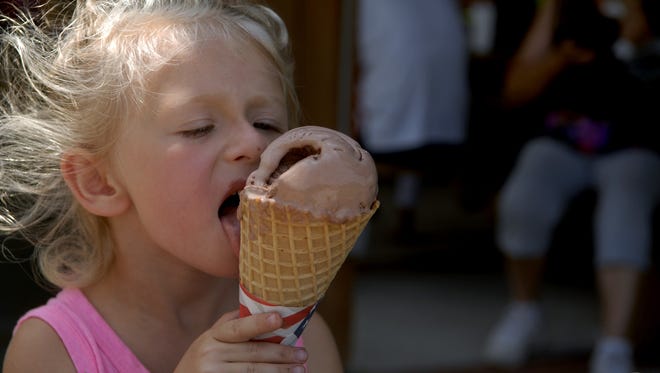 Summer Burkhardt, 5, works on an ice cream cone as big as her head during the Ice Cream Social at Farnsley -Moremen Landing Sunday afternoon. July 12, 2015