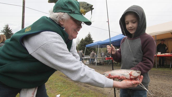 Poggie Club member Carol Hafner introduces the sport to a young fisherman during the club's Kids Fishing Day in April.