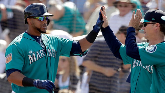 The Mariners' Nelson Cruz (left) celebrates with manager Scott Servais after hitting a solo home run in the second inning Sunday against San Diego.